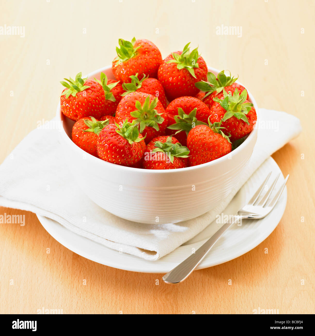 Tazón de fresas de verano fresco con horquilla de plata. Foto de stock