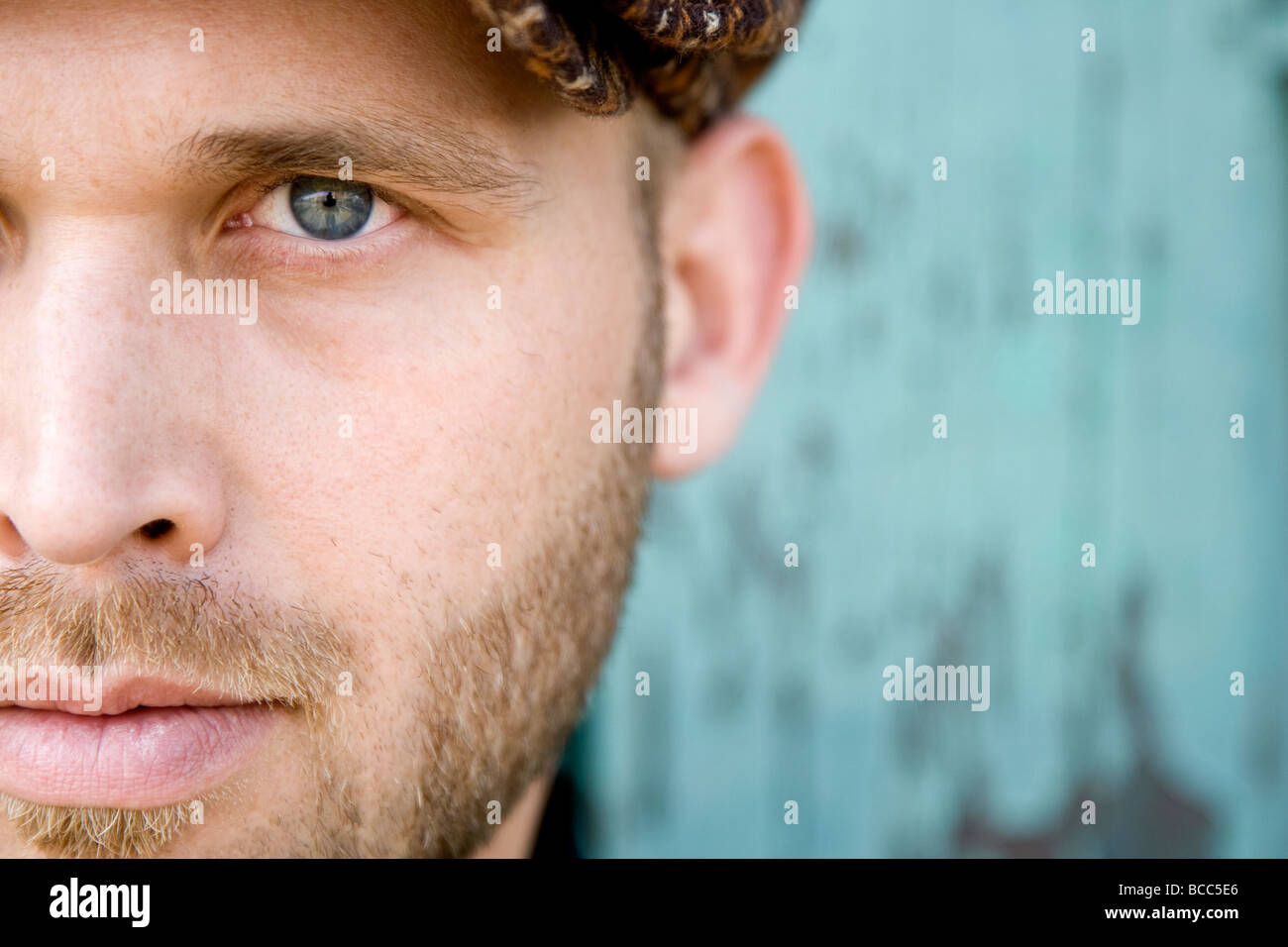 Un retrato de un hombre de ojos azules con una corta barba rubia mirando a  la cámara. La imagen se recorta, mostrando sólo la mitad de su rostro  Fotografía de stock 