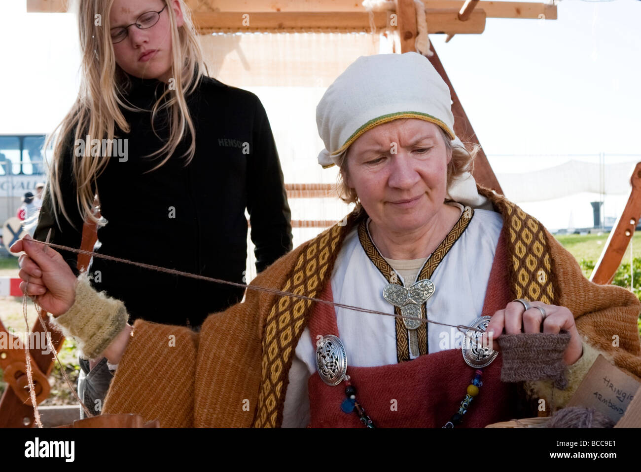 Mujer tejiendo, ella está vistiendo ropa tradicional de la era vikinga. Festival Vikingo en Hafnarfjordur, la mayor zona de Reykjavik, Islandia Foto de stock
