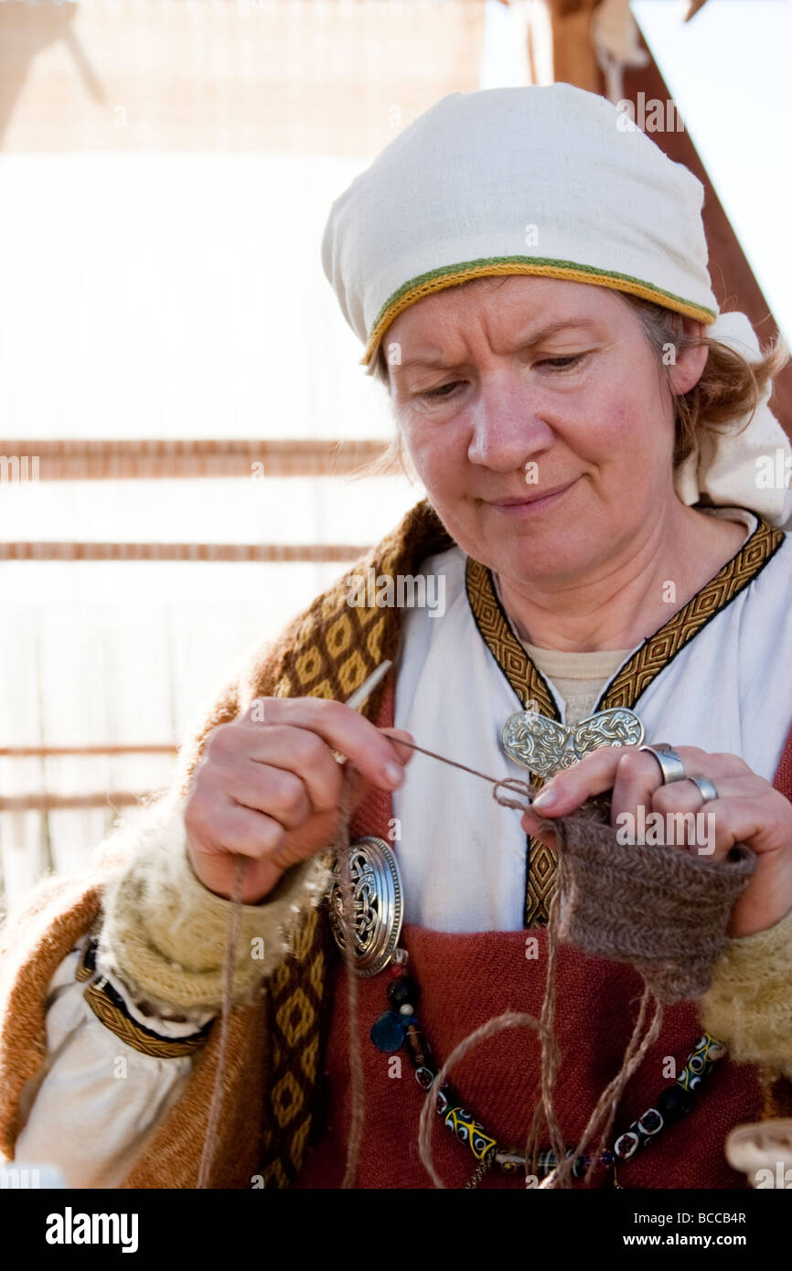 Mujer tejiendo, ella está vistiendo ropa tradicional de la era vikinga. Festival Vikingo en Hafnarfjordur, la mayor zona de Reykjavik, Islandia Foto de stock