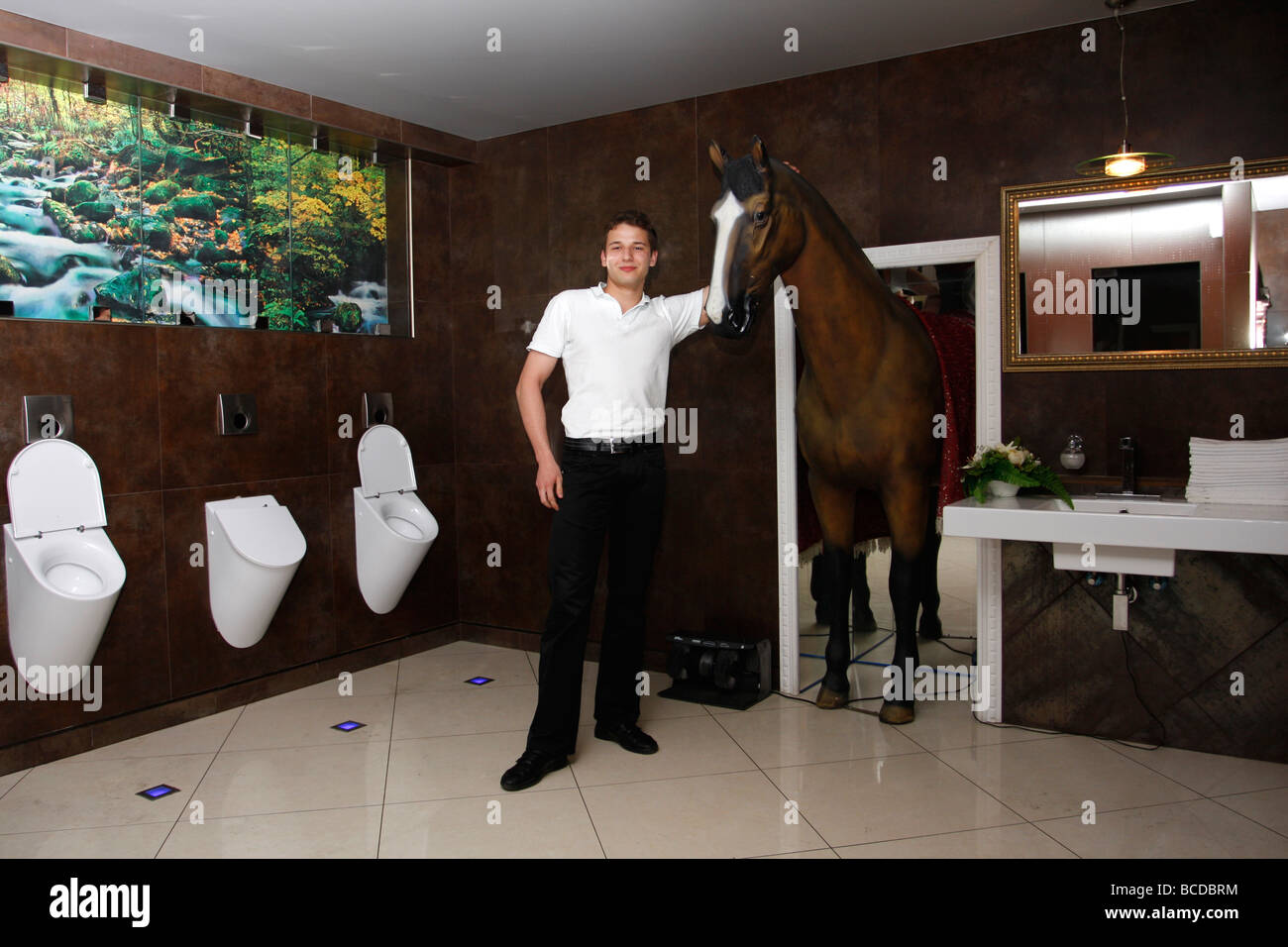 Joven plantea en un retrete con caballo popular estatua en uno de los