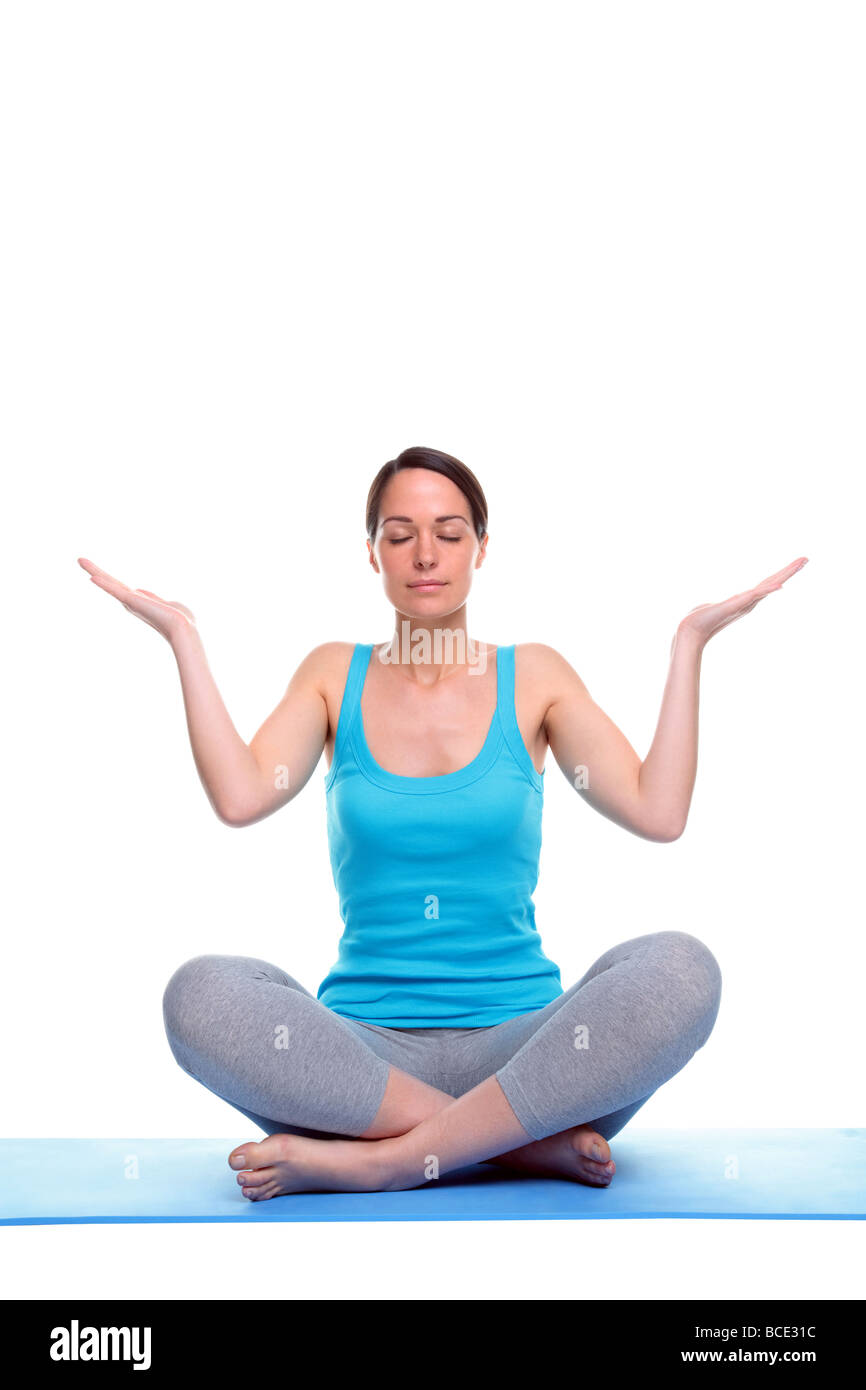 La mujer se sentó en una posición de yoga meditación aislado sobre un fondo blanco. Foto de stock