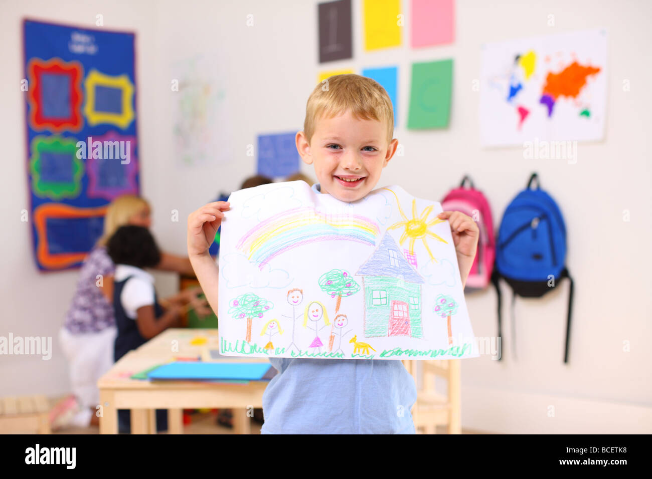 Niño de preescolar sosteniendo ilustraciones Foto de stock