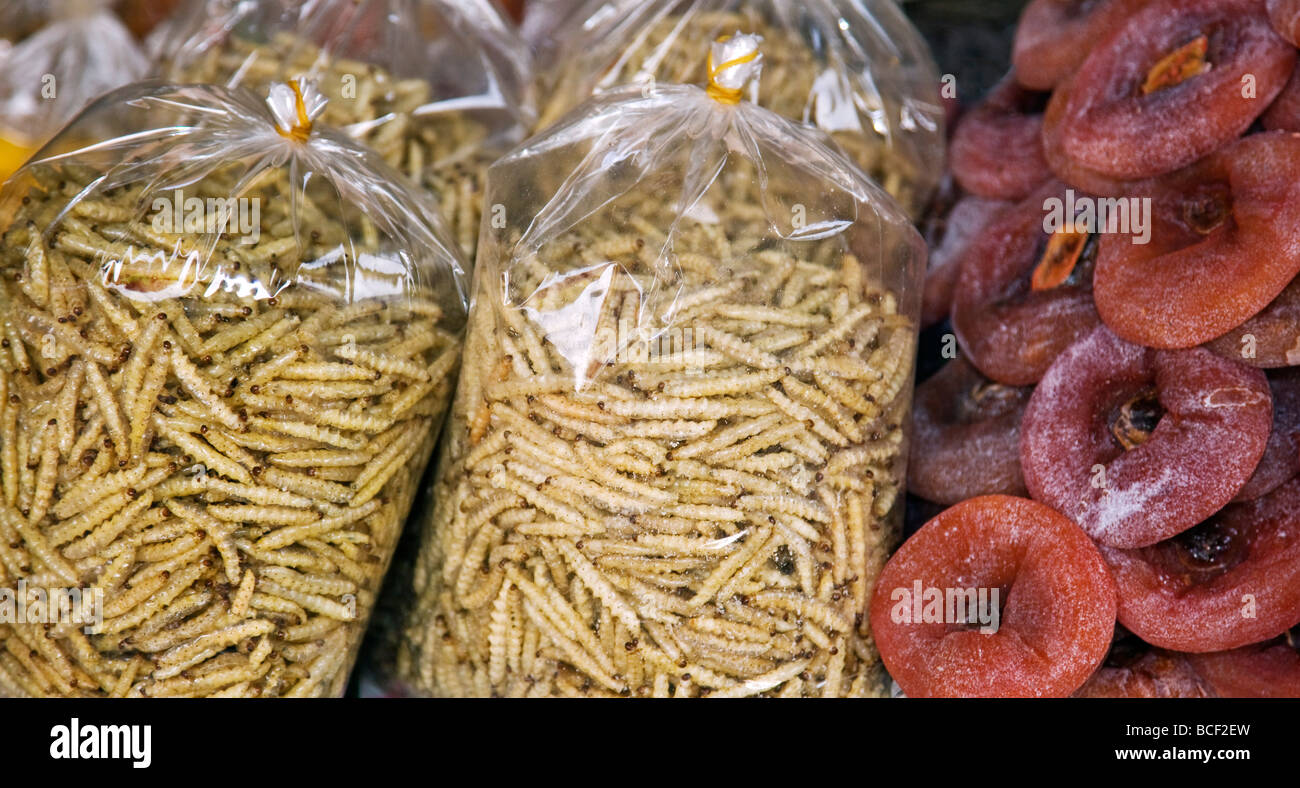 Myanmar, Birmania, Kengtung. Un stand en Kengtung mercado ofrece frutos secos fritos y gusanos de bambú que son sabroso cuando crujiente. Foto de stock