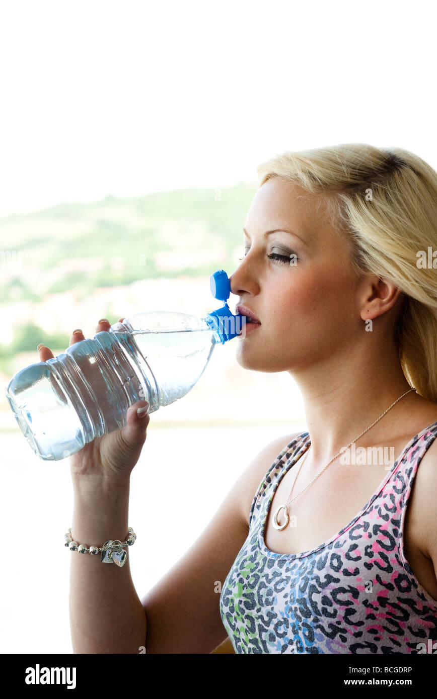 Mujer beber agua mineral de botella Foto de stock