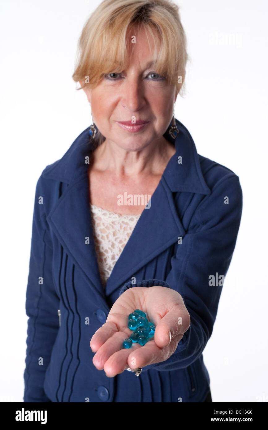 Mujer de más edad con una mano llena de medicamentos Foto de stock