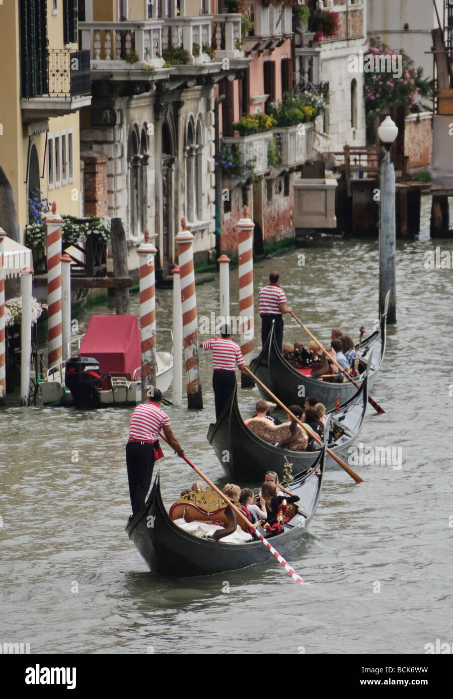 - Venecia gondoleros y góndolas tres en una fila en el Grand Canal - con traje coincidente todo sincronizado Foto de stock