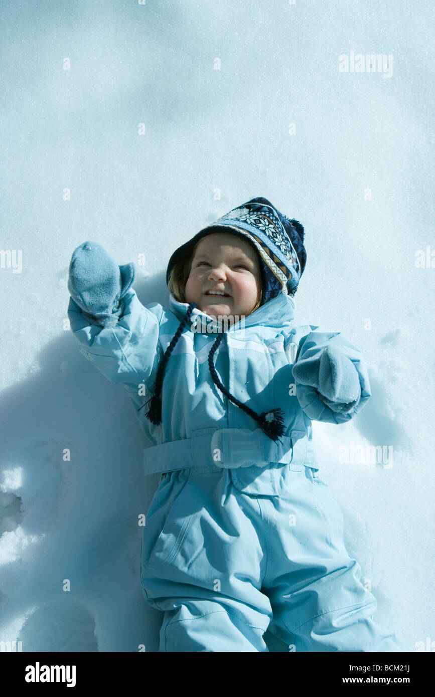 Niña Niño acostado en la nieve, vestido con traje de esquí, sonriendo  Fotografía de stock - Alamy