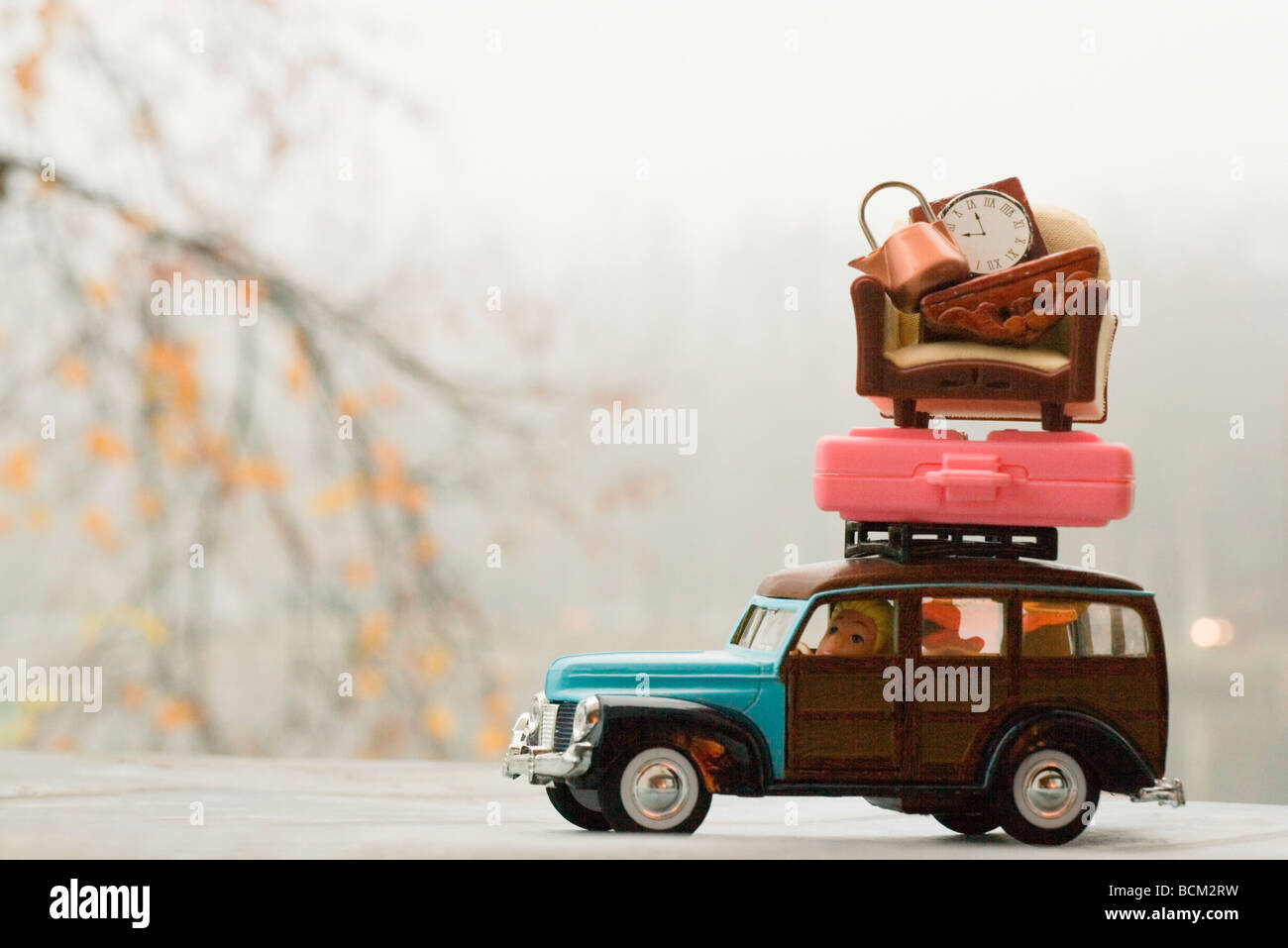 Coche de juguete con el equipaje y muebles apilados encima Foto de stock