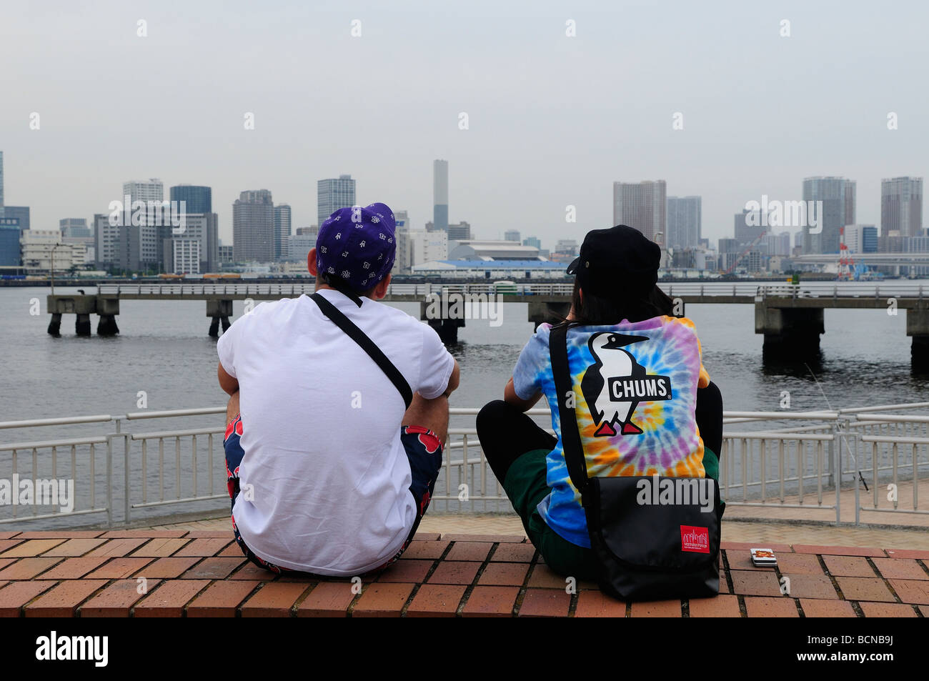 Los jóvenes japoneses disfrutando del paisaje urbano de la bahía de Tokio desde Odaiba Tokio JAPÓN Foto de stock