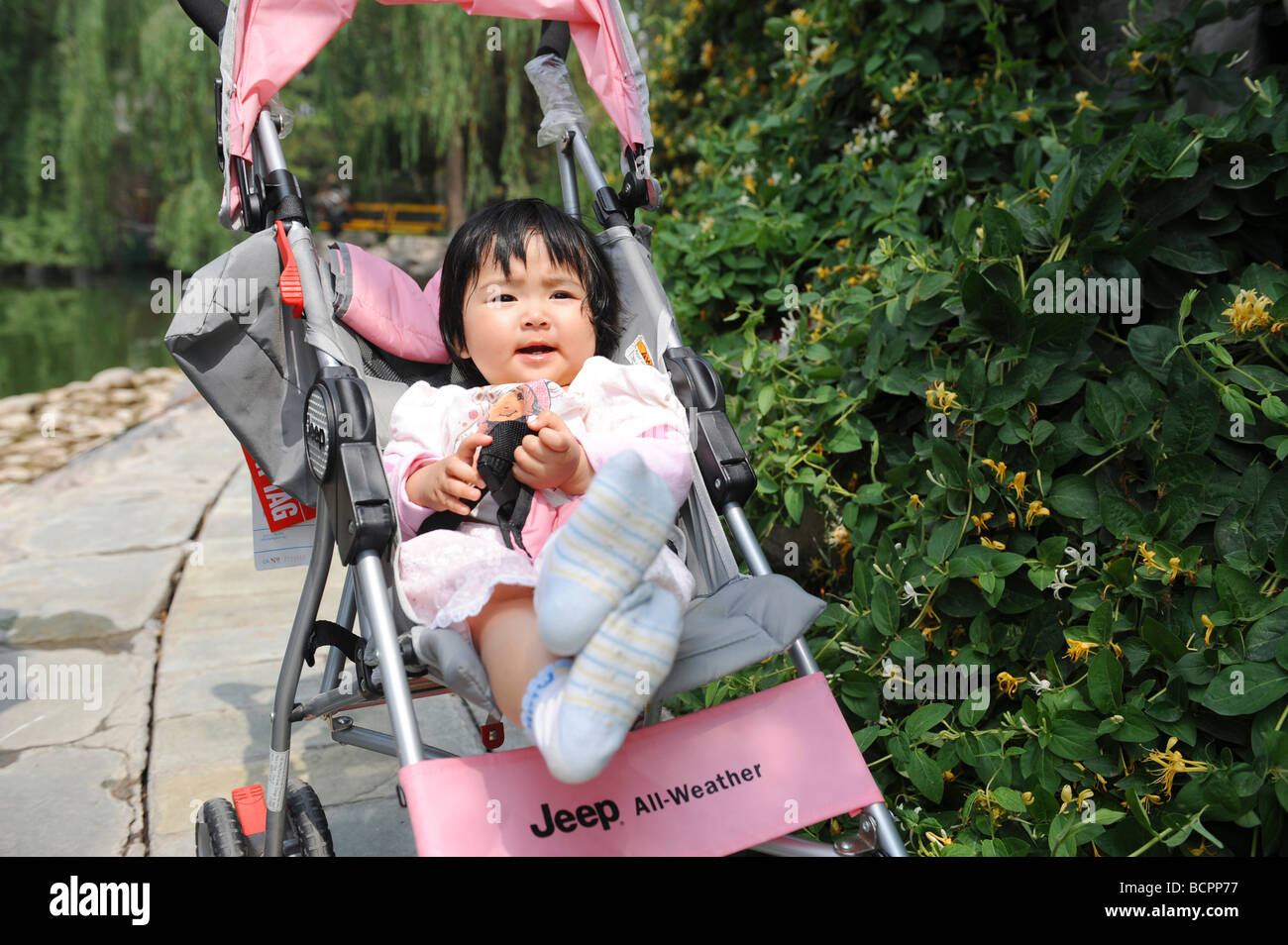 Bebé china chica sentada sobre una marca Jeep cochecito en un parque,  Chengdu, provincia de Sichuan, China Fotografía de stock - Alamy
