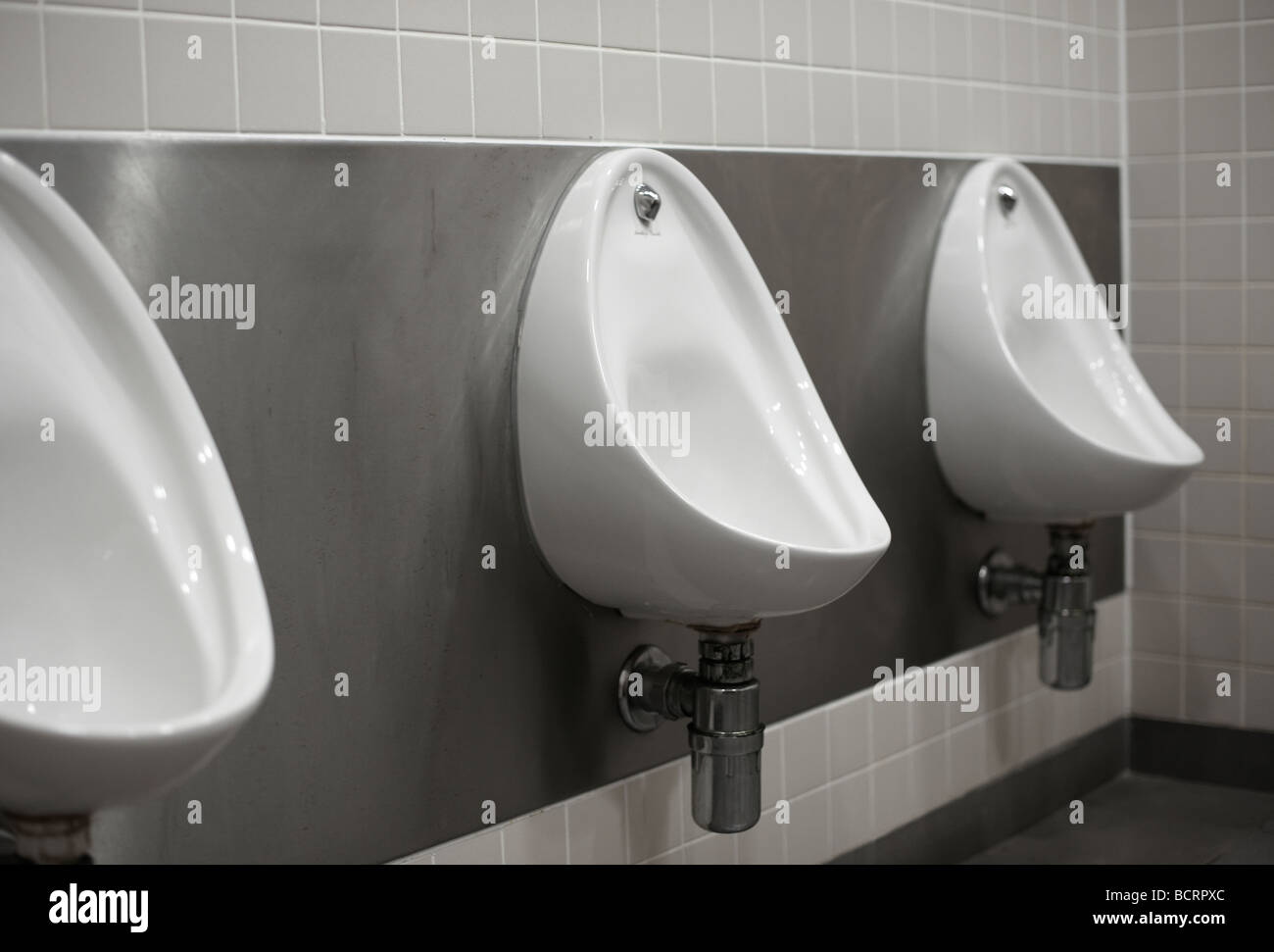 Tres mens urinarios en aseo público Foto de stock