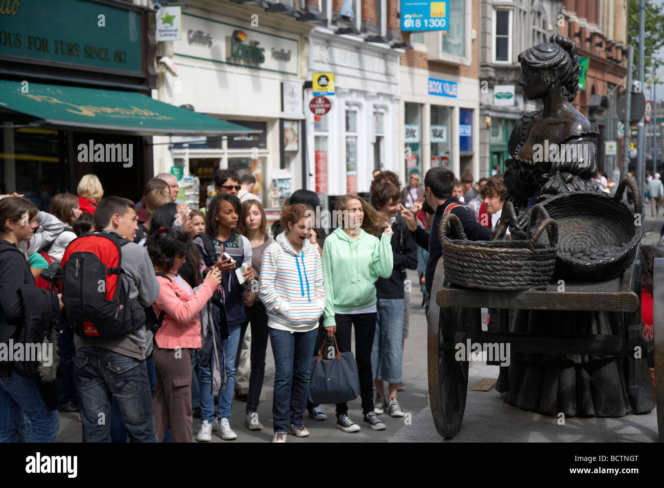 Grupo de turistas en un paseo de Dublín en el Molly Malone estatua en el centro de la ciudad de Dublin república de Irlanda Foto de stock