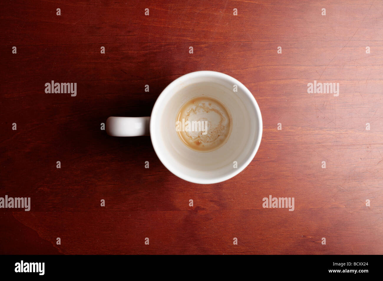 La taza de café vacía sobre una mesa de madera marrón Foto de stock