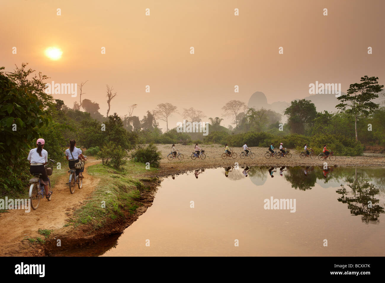Los ciclistas en horas de la madrugada, hora punta en el campo cerca de Vang Vieng, en Laos Foto de stock