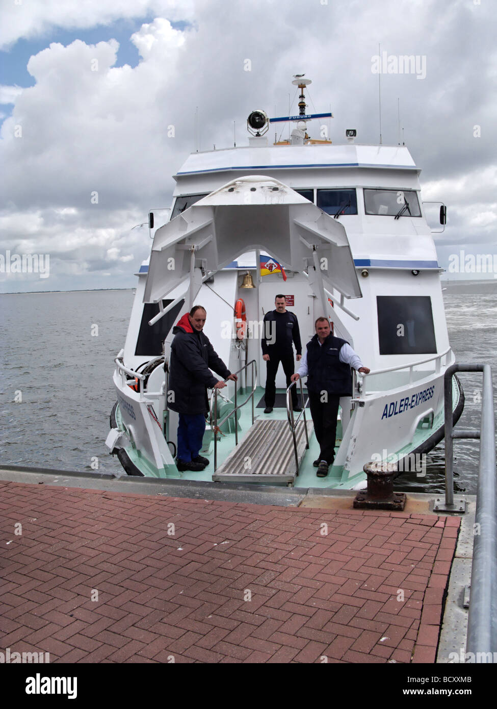 Los miembros de la tripulación en el ferry expreso Adler esperando para embarcar pasajeros de Frisia septentrional isla Amrum Alemania Foto de stock