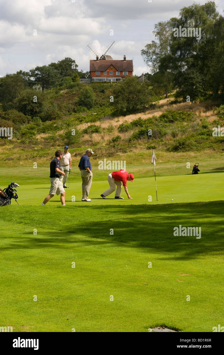 Los golfistas en Reigate Heath Golf Course con el Clubhouse en el fondo Surrey, Inglaterra Foto de stock