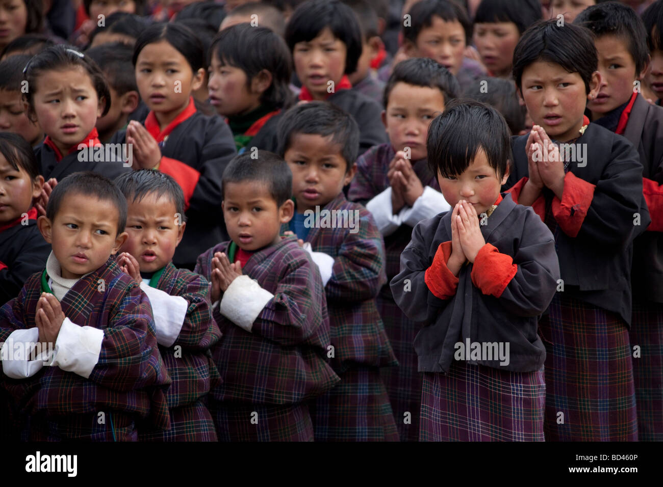 Grupo de jóvenes escolares en uniformes rojos puños manguitos orando en  general en la escuela infantil 91949 Bhutan-Wangdue Fotografía de stock -  Alamy