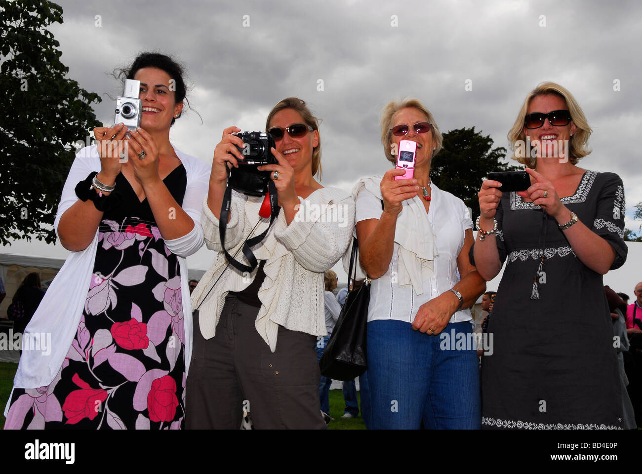 Cuatro mujeres en la aldea Oakhanger espectáculo con sus cámaras, Oakhanger, Hampshire, Reino Unido. Foto de stock