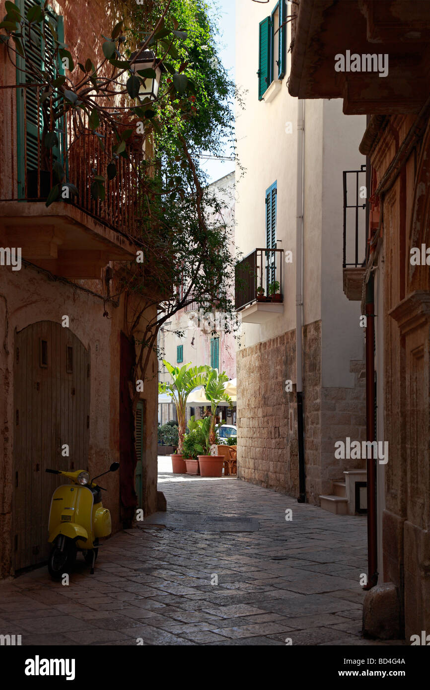 Scooter aparcado en una calle angosta, Polignano a Mare, Puglia, Italia. Foto de stock