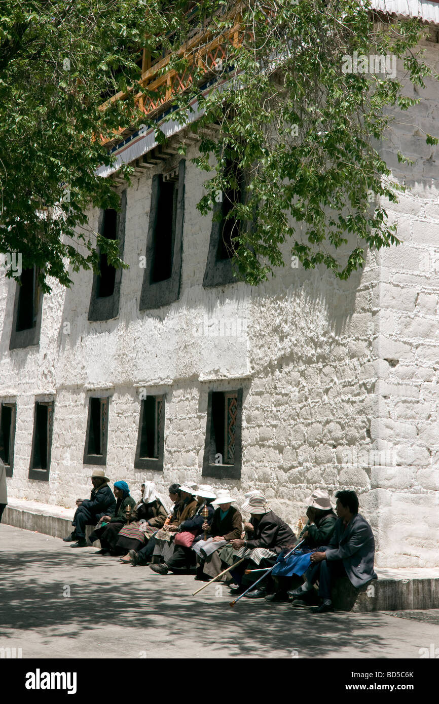 Los peregrinos descansando al lado de el Jokhang después de completar el circuito de Barkhor Foto de stock
