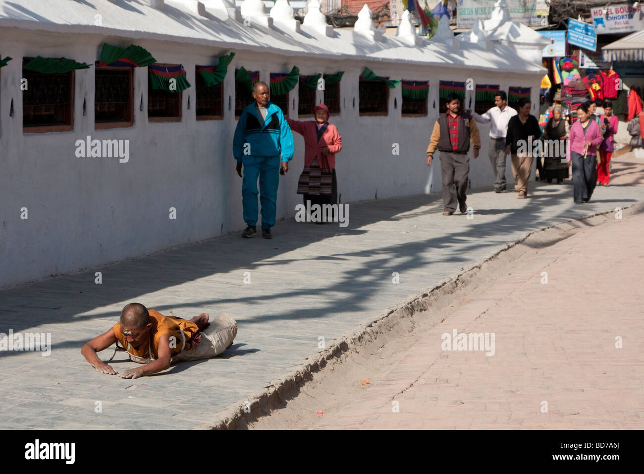 Bodnath, Nepal. Un budista devoto busca el mérito, bendiciones y el perdón por rodear la Stupa en una serie de postraciones. Foto de stock
