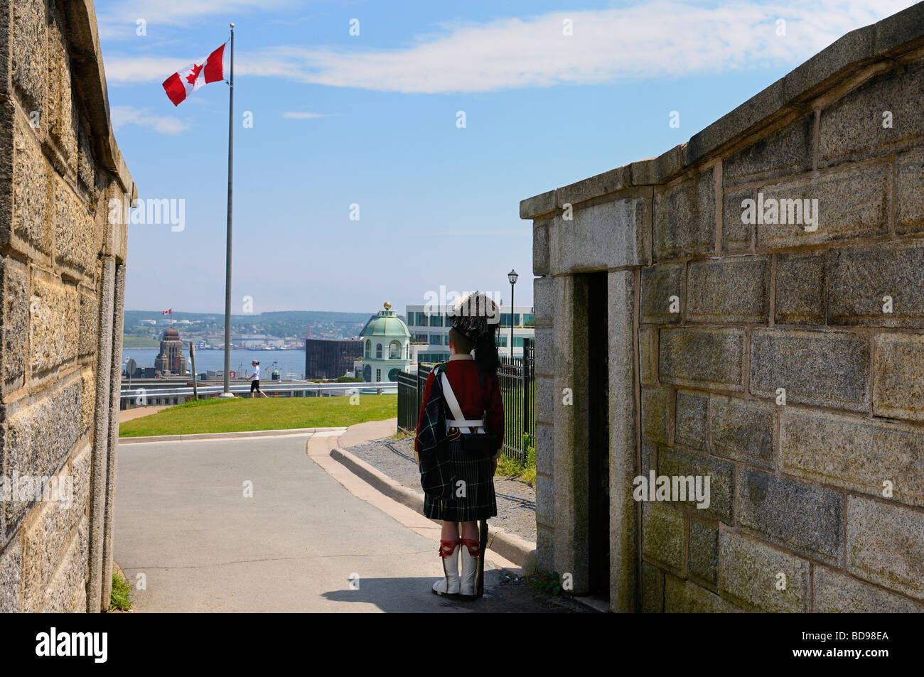 78highland sentinel viendo en la puerta de la ciudadela de Halifax, Nova Scotia con bandera canadiense Foto de stock