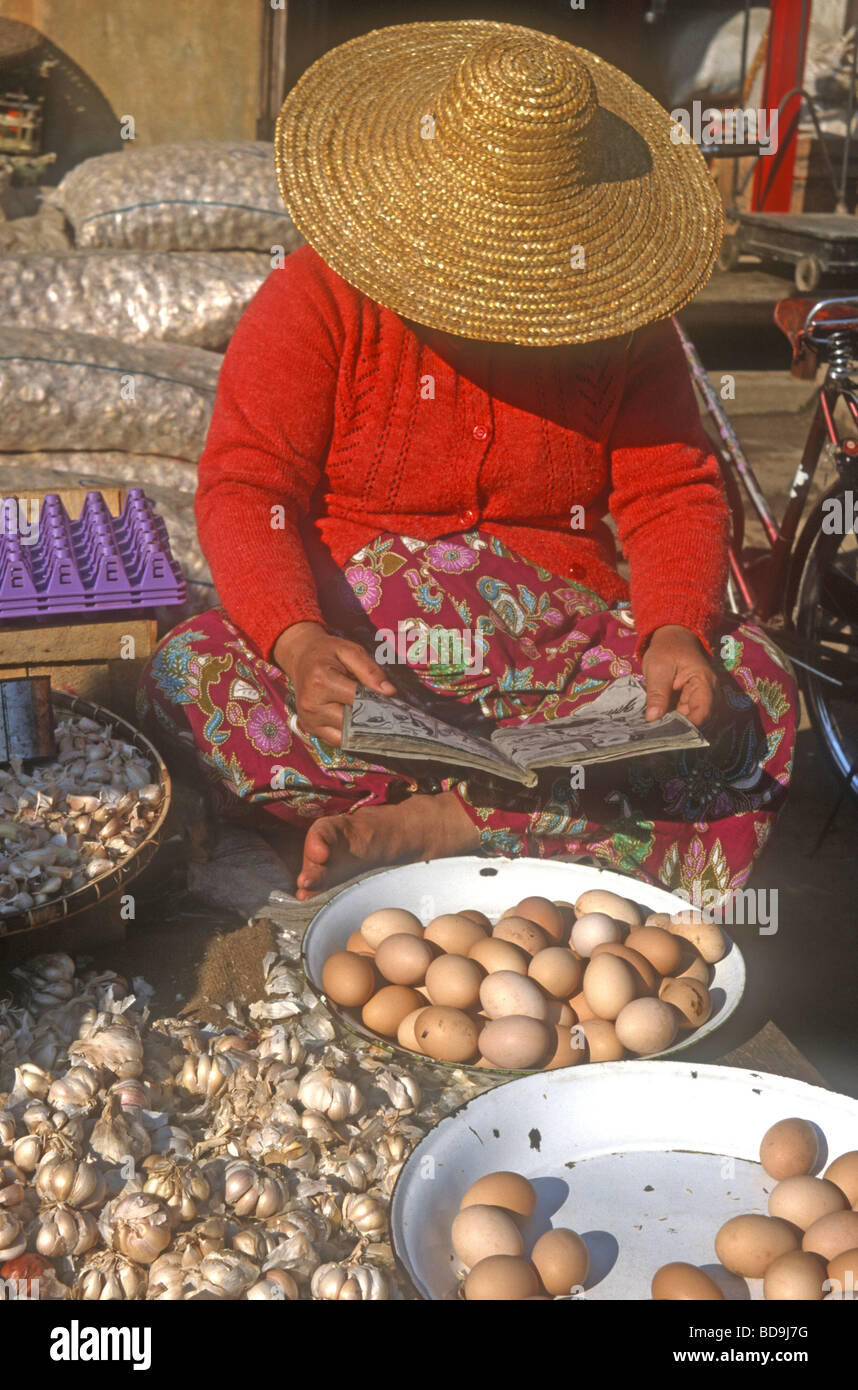 Mujer birmana ,llevar sombrero de paja tradicional ,vendiendo huevos en el mercado local a Myitkyina en el norte de Myanmar Foto de stock