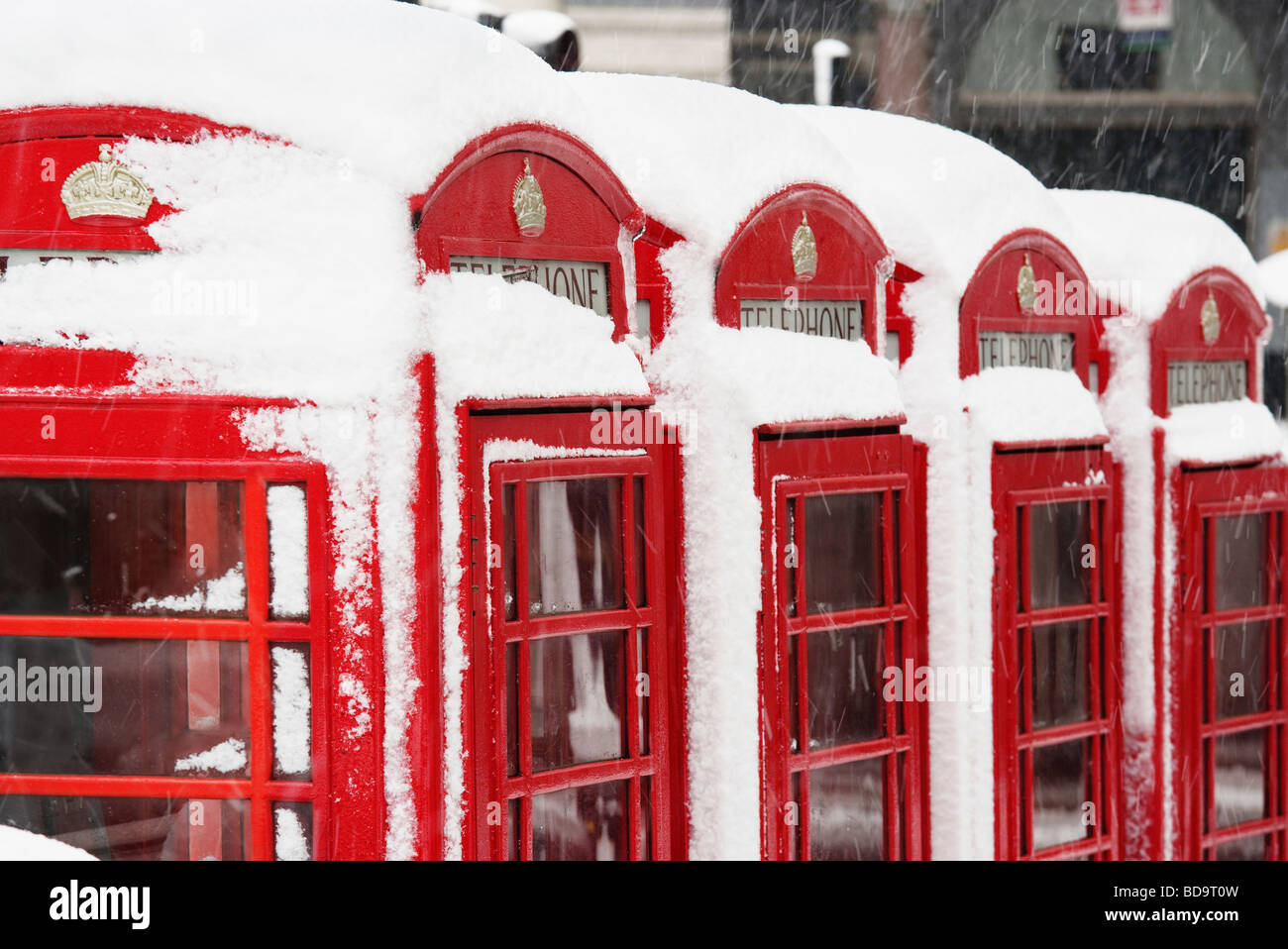 Nieve en cabinas telefónicas rojas de Londres, Inglaterra Foto de stock