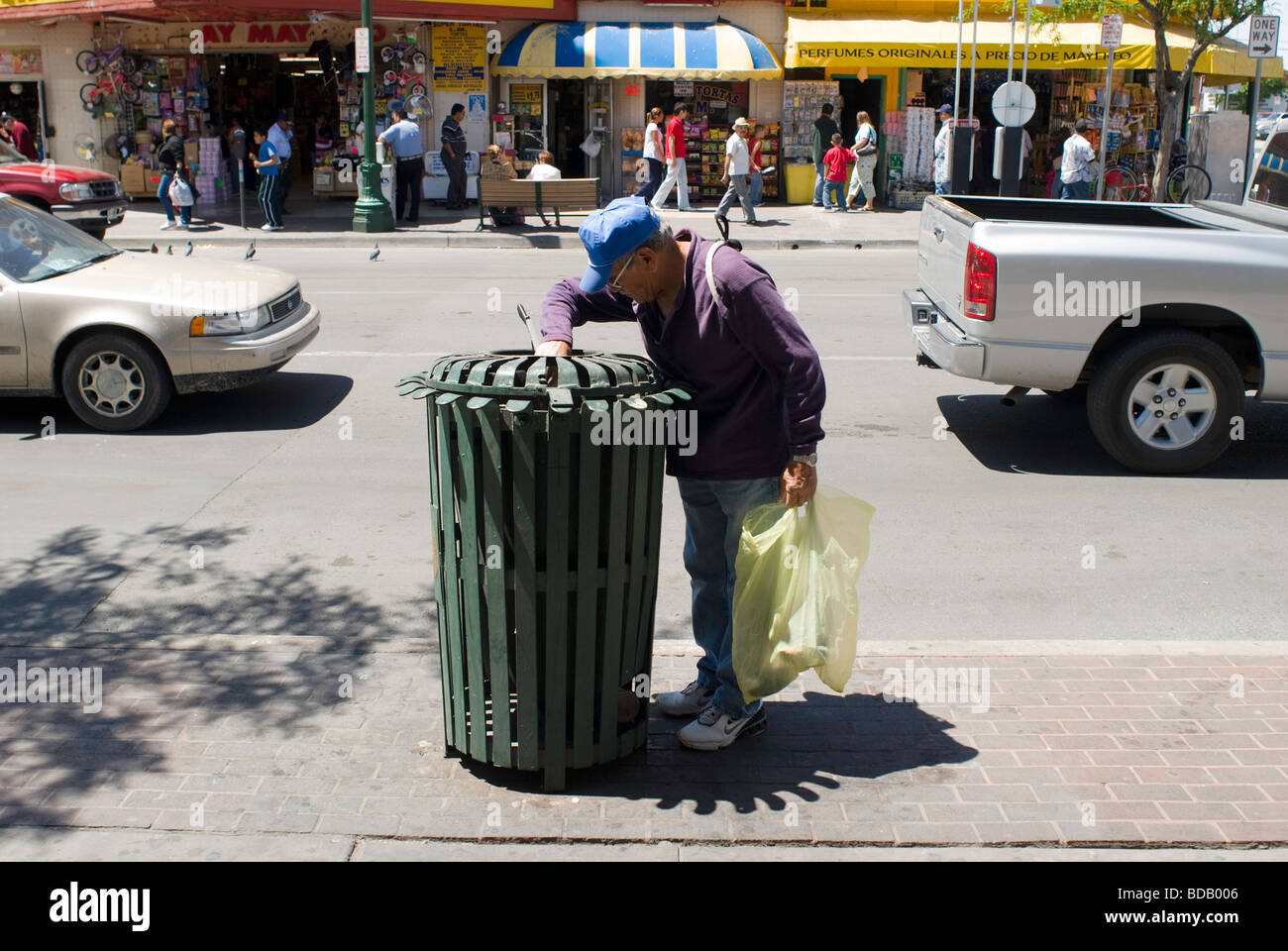 Un hombre rummages público a través de un contenedor de basura en el centro de El Paso Foto de stock