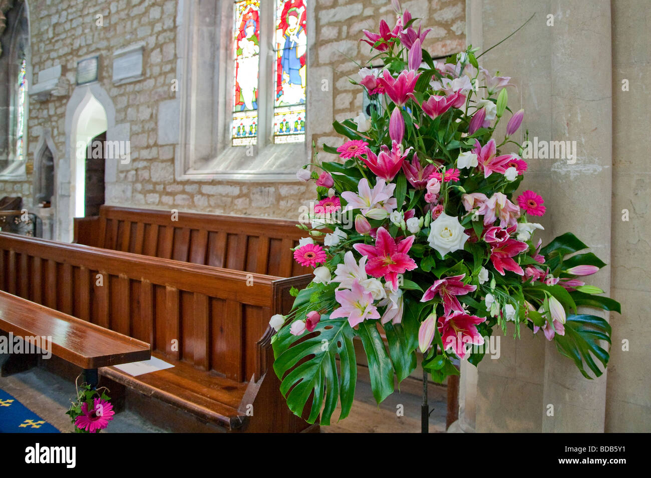 Flores de la boda en una iglesia con vidriera en el fondo Foto de stock