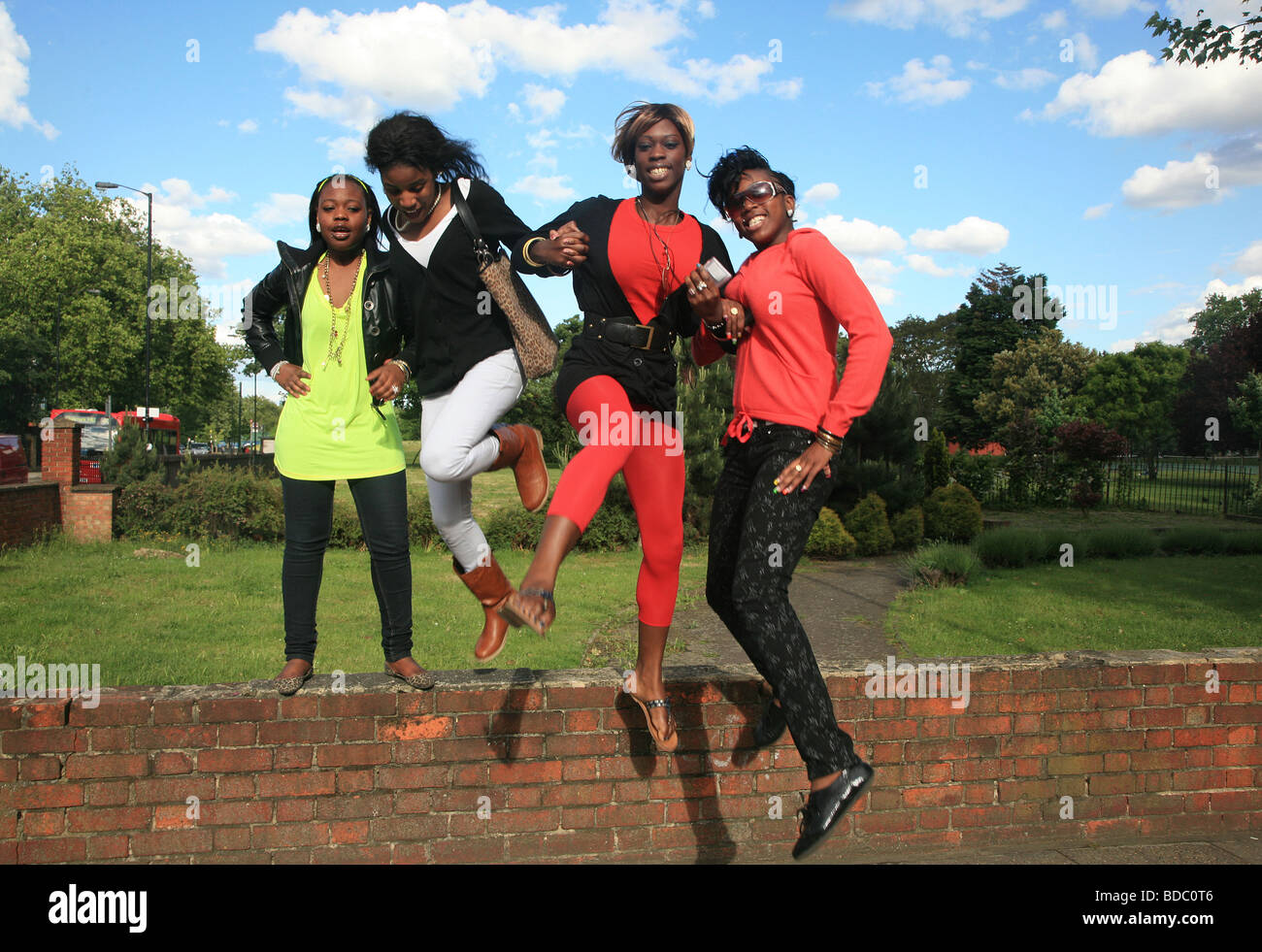 4 elegante negro amigos saltando juntos, London, South, Camberwell UK 2009 Foto de stock