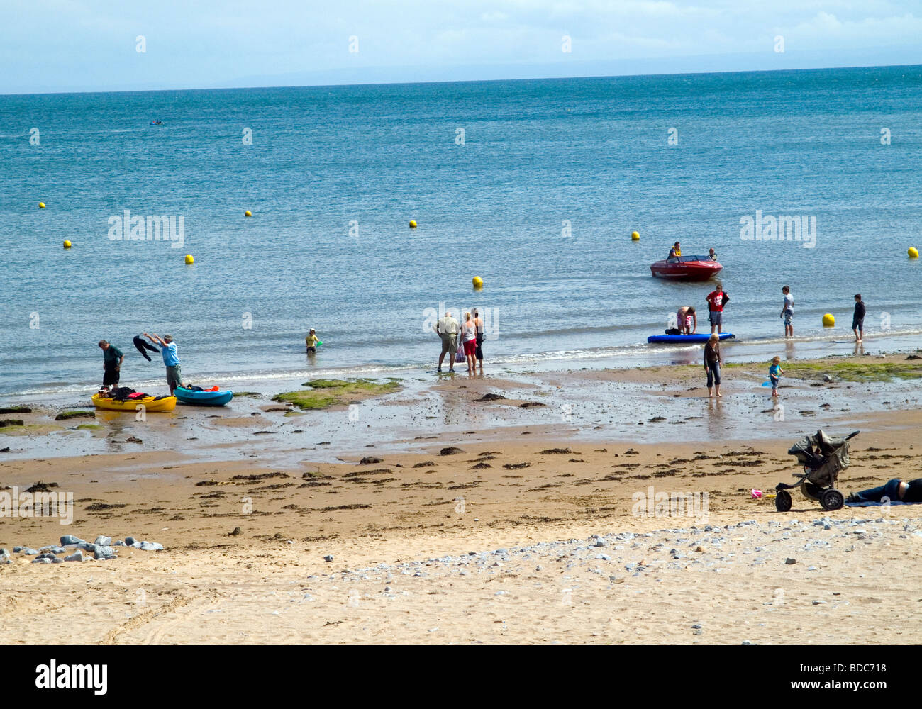 La gente en la playa y remar en el mar en Port Eynon, Península de Gower Swansea Wales UK Foto de stock