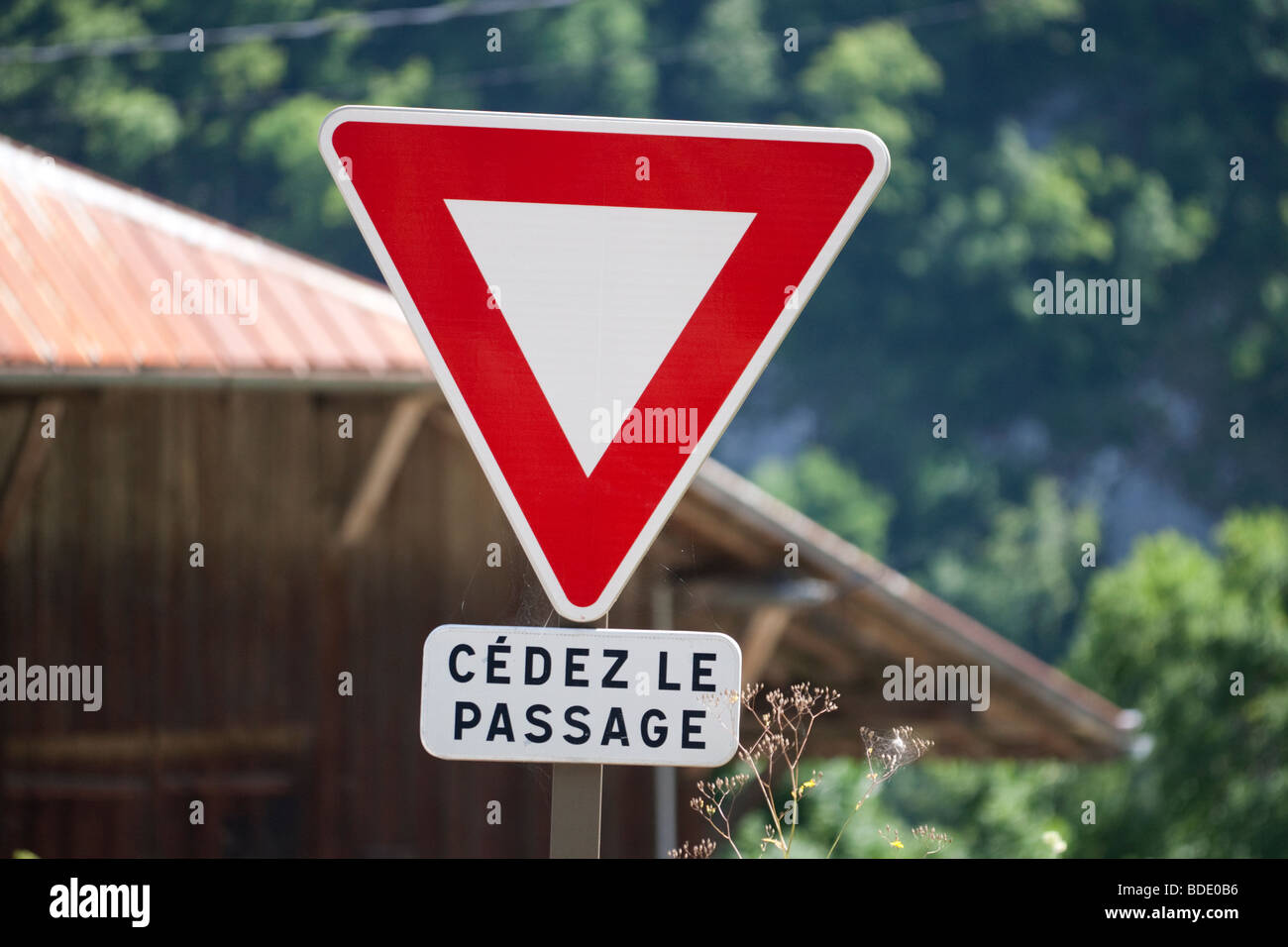 Ceder o Cedez francés le Passage de signo en cruce de carreteras Foto de stock