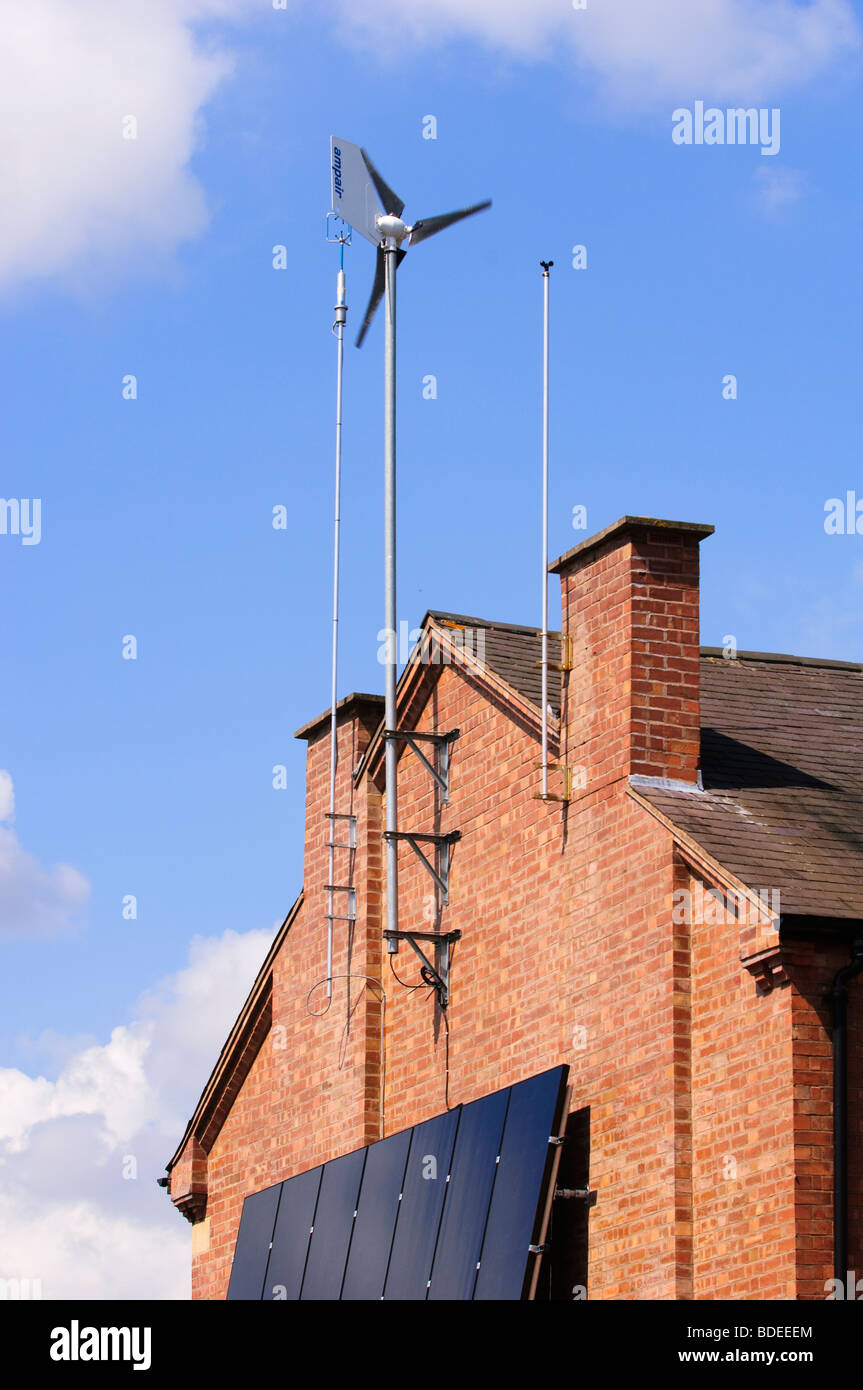 Generador de viento y paneles solares, pegada a la pared sur de una casa residencial en Leamington Spa, Warwickshire, Reino Unido. Foto de stock