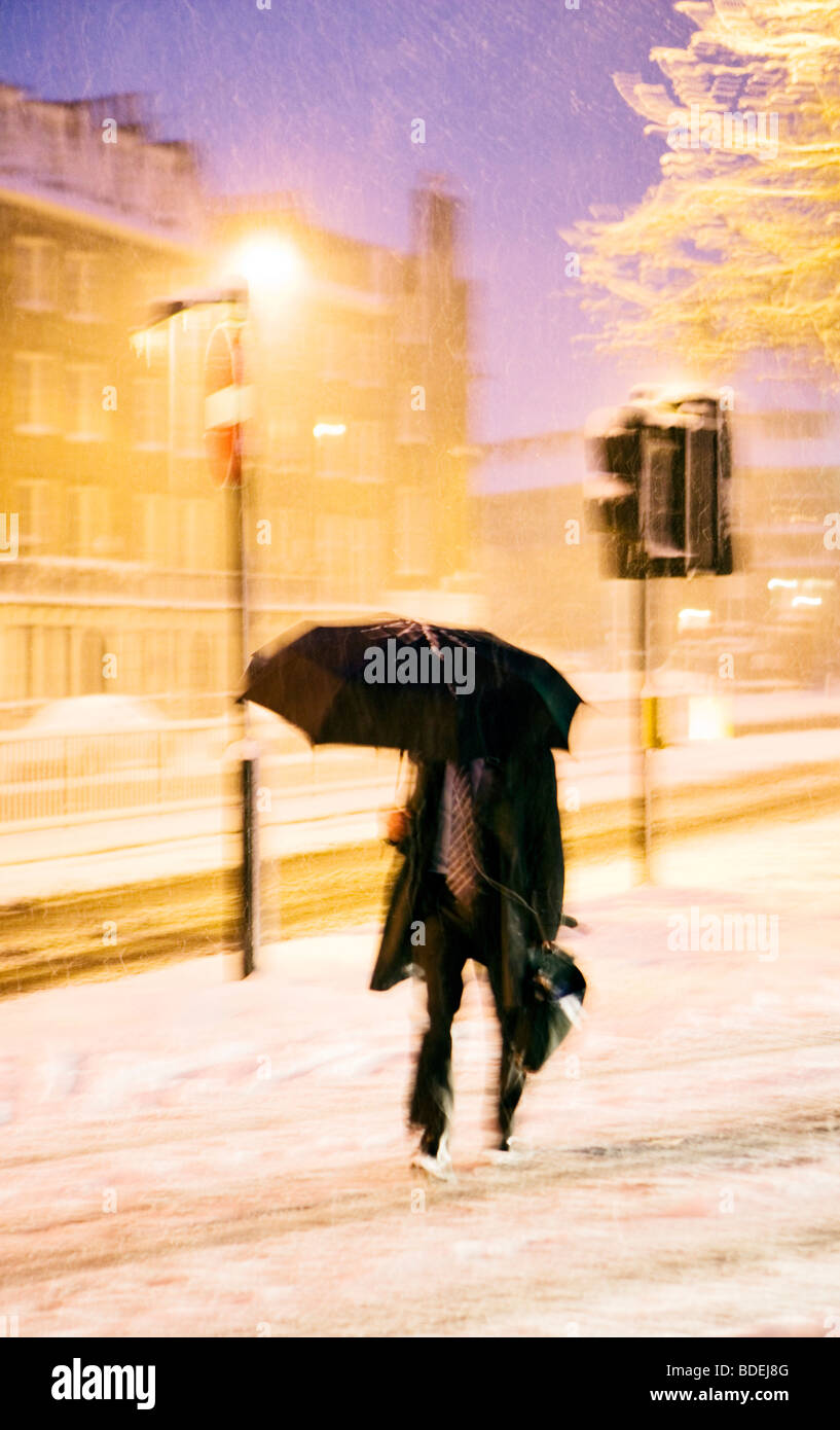 Hombre con sombrilla batallas intensas nevadas, Londres, Inglaterra, Reino Unido, Europa Foto de stock