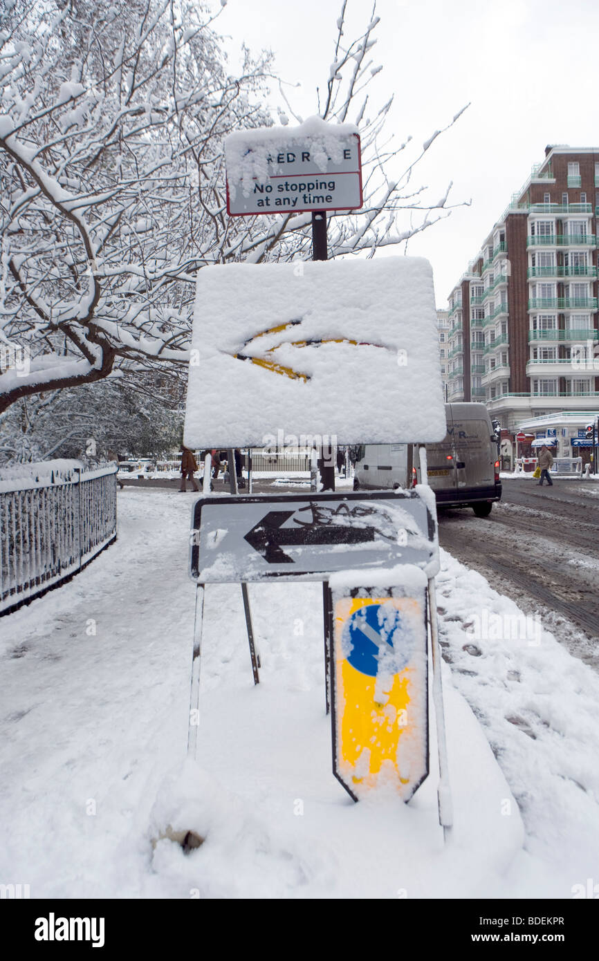 Señal de giro a la izquierda modificado después de fuertes nevadas, Londres, Inglaterra, Reino Unido, Europa Foto de stock