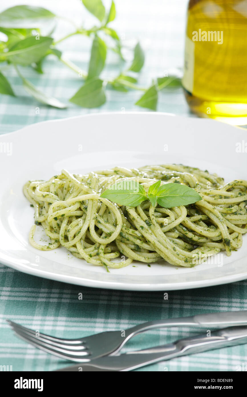 Espaguetis con salsa pesto y hojas de albahaca Foto de stock
