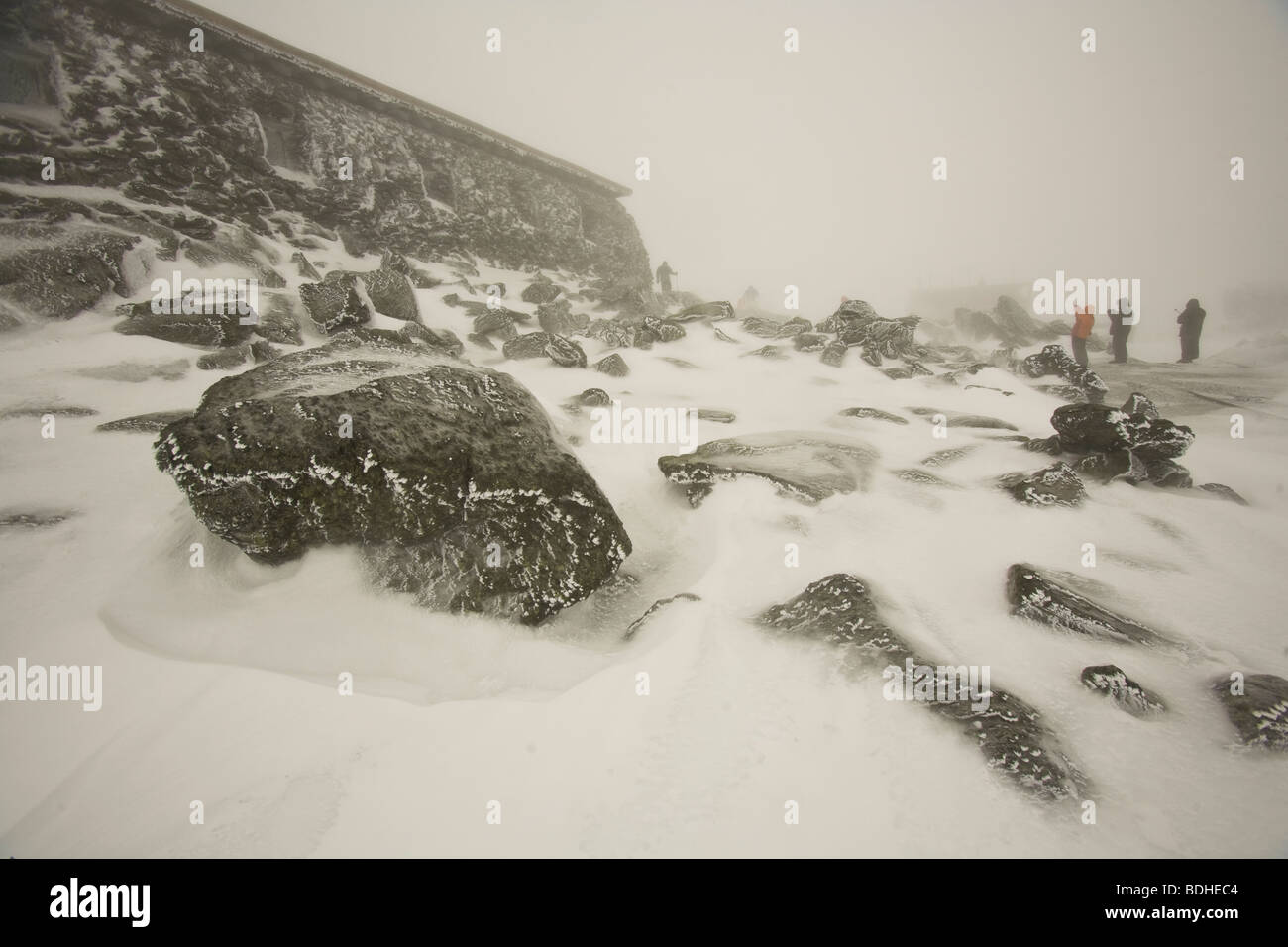 Un grupo de personas experimenta los graves elementos de viento y temperatura en Mt. La cumbre de Washington en invierno. Foto de stock