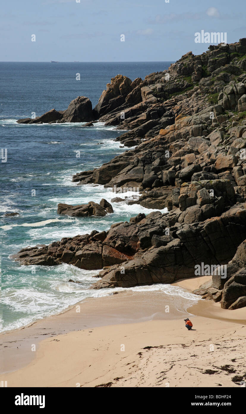 Un hombre que toma una fotografía de las olas en la playa de Cala Porthchapel Cornwall, Inglaterra Foto de stock