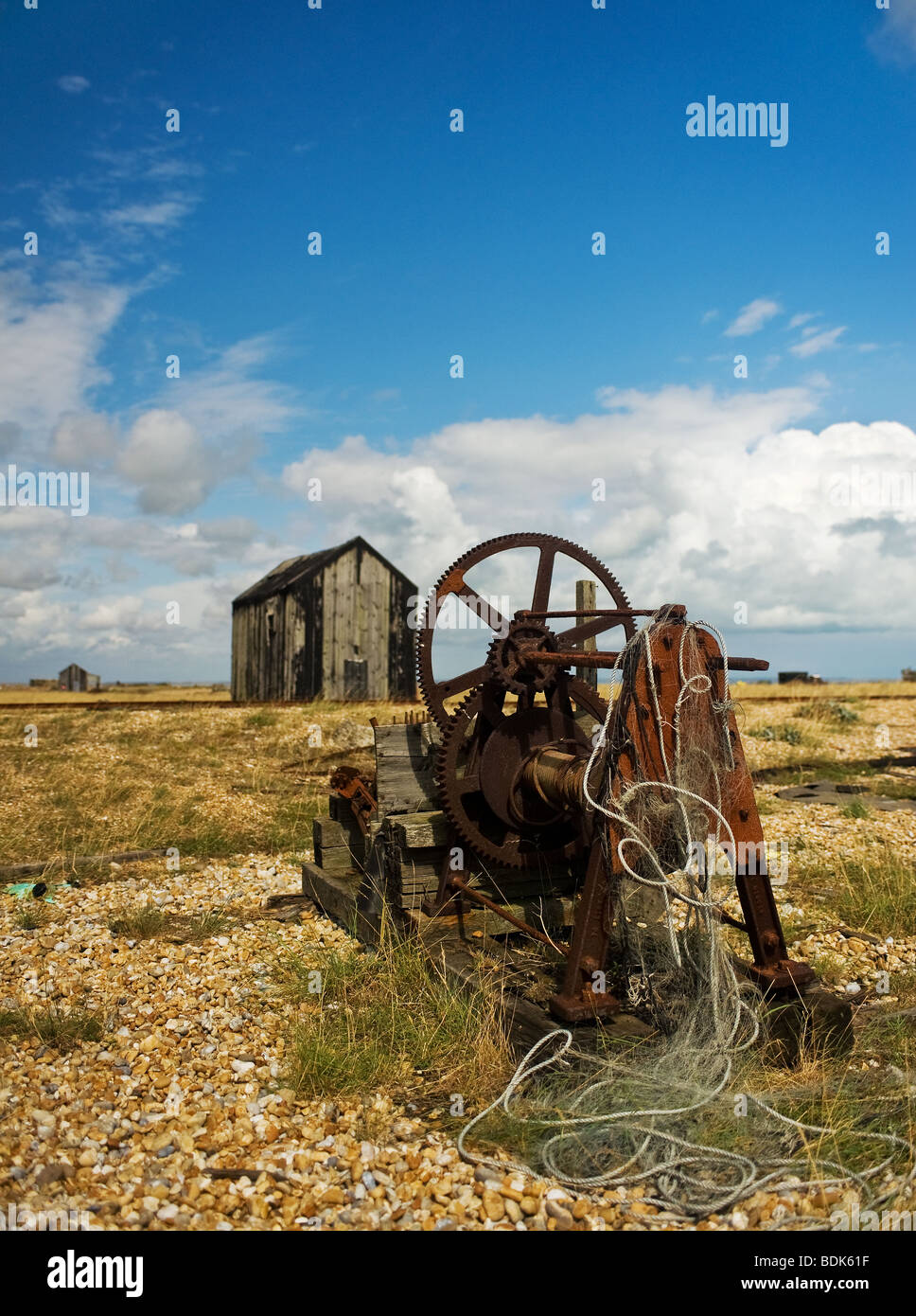 Abandonada la maquinaria oxidada y chozas de madera sobre la playa de guijarros en Dungeness en Kent. Foto de stock
