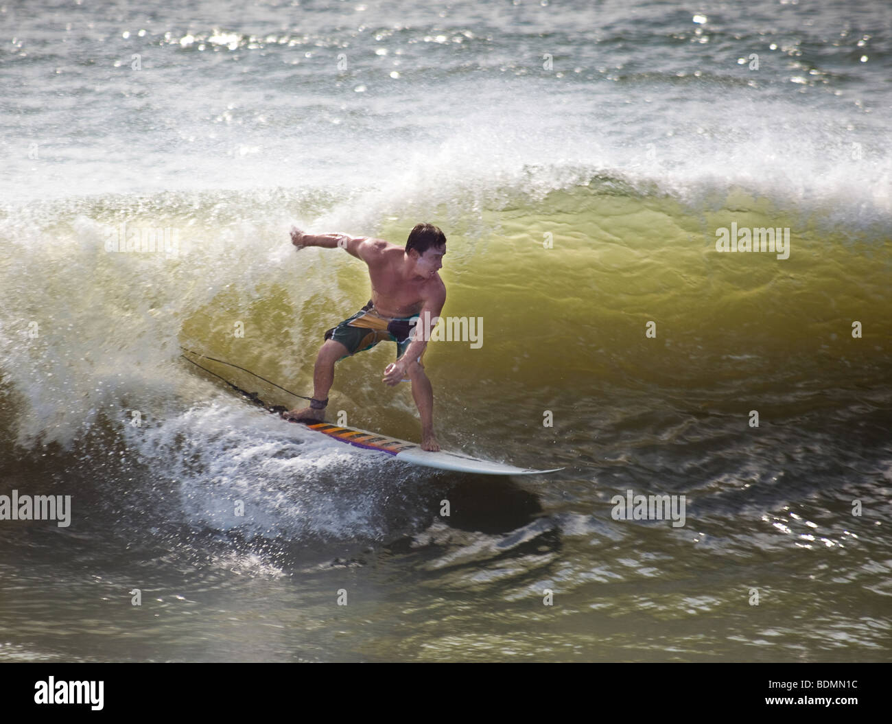 Un surfista aprovecha el océano oleaje generado por el paso de un huracán a lo largo de la costa de Carolina del Sur en Folly Beach, SC Foto de stock