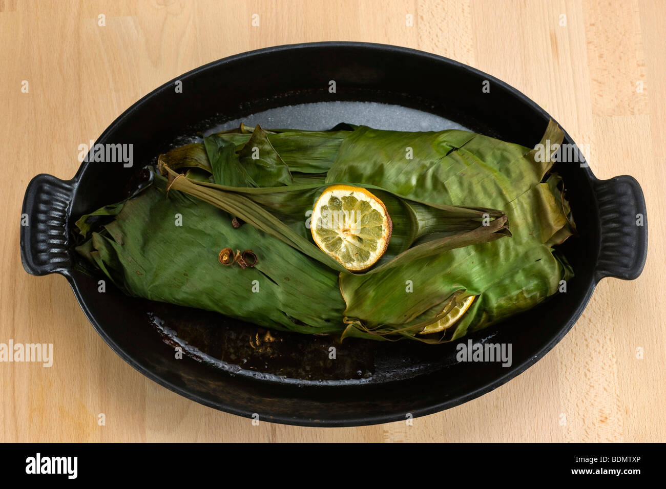 Pescado cocinado en hojas de plátano Foto de stock