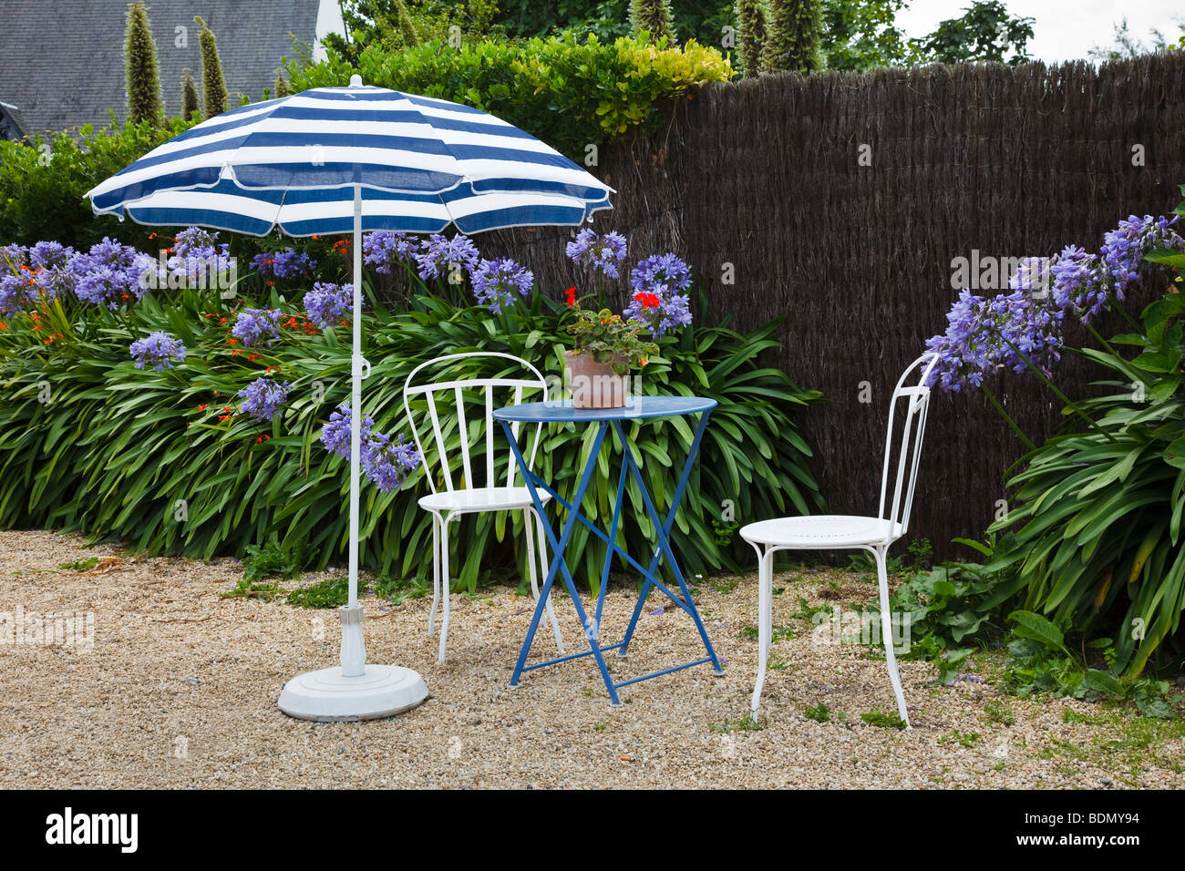Mesa y sillas en el jardín de un café francés en la Ile de Bréhat, Bretaña Foto de stock