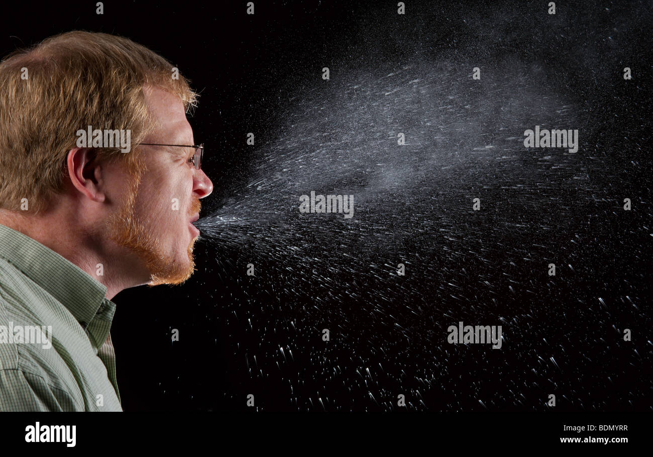 Hombre estornudos, mostrando el spray de moco y saliva que es potencialmente infeccioso Foto de stock