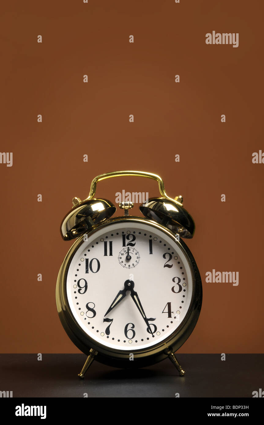 Reloj despertador con espacio para texto sobre un fondo marrón Foto de stock