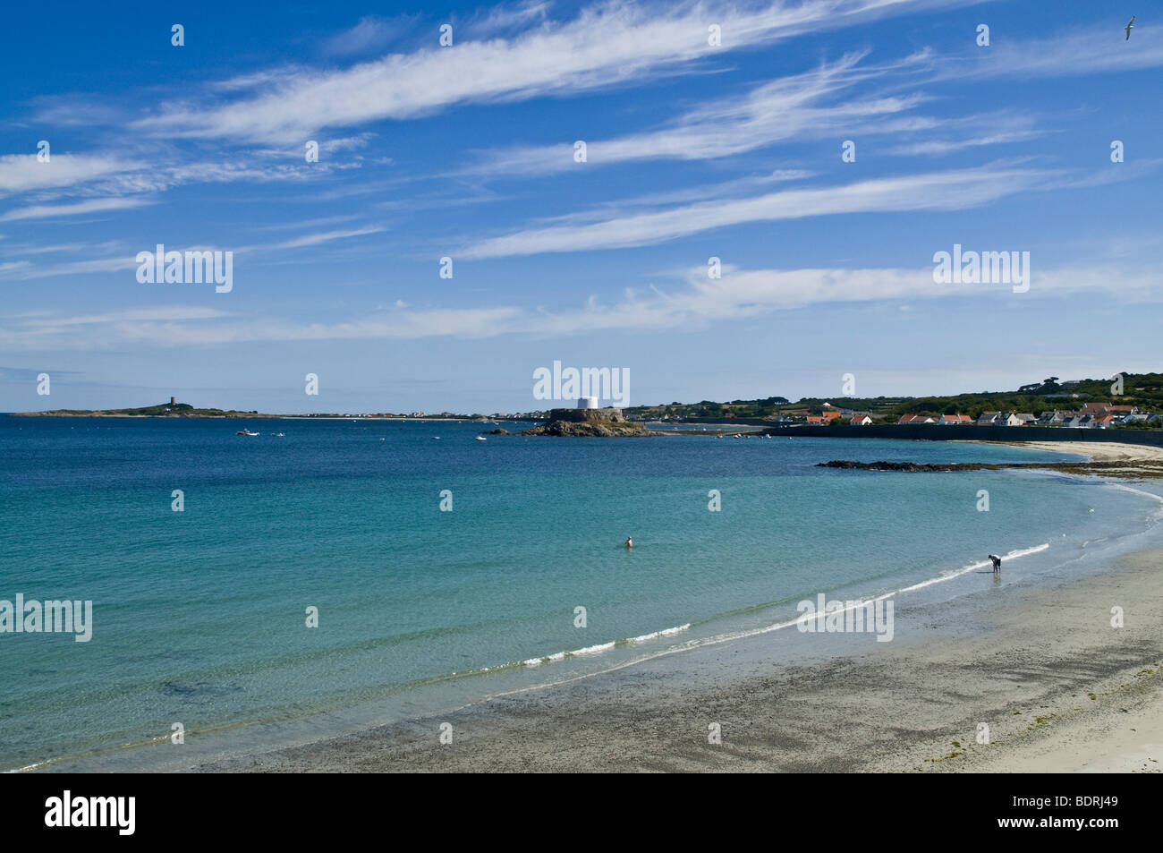 dh Rocquaine Bay TORTEVAL GUERNSEY Boy piscina al aire libre mujer remando playa de arena costa mar arena cielo de costa Foto de stock