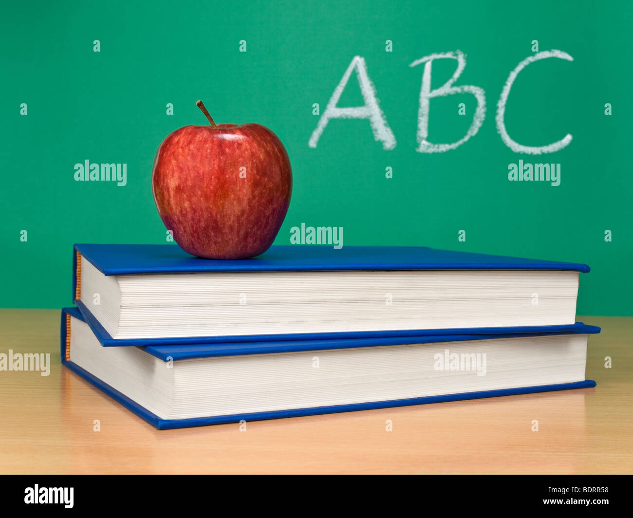 ABC escrito en una pizarra con una manzana más libros. Foto de stock