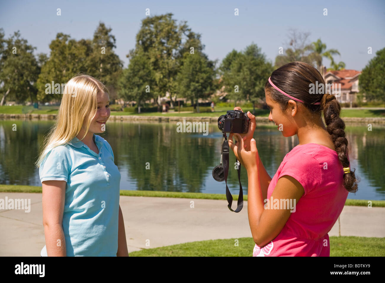 Dos chicas de 11-12 años y años colgando Hispanic junior high niña toma la foto amigo caucásico.La gente joven de la naturaleza, un entorno natural Myrleen Pearson Foto de stock
