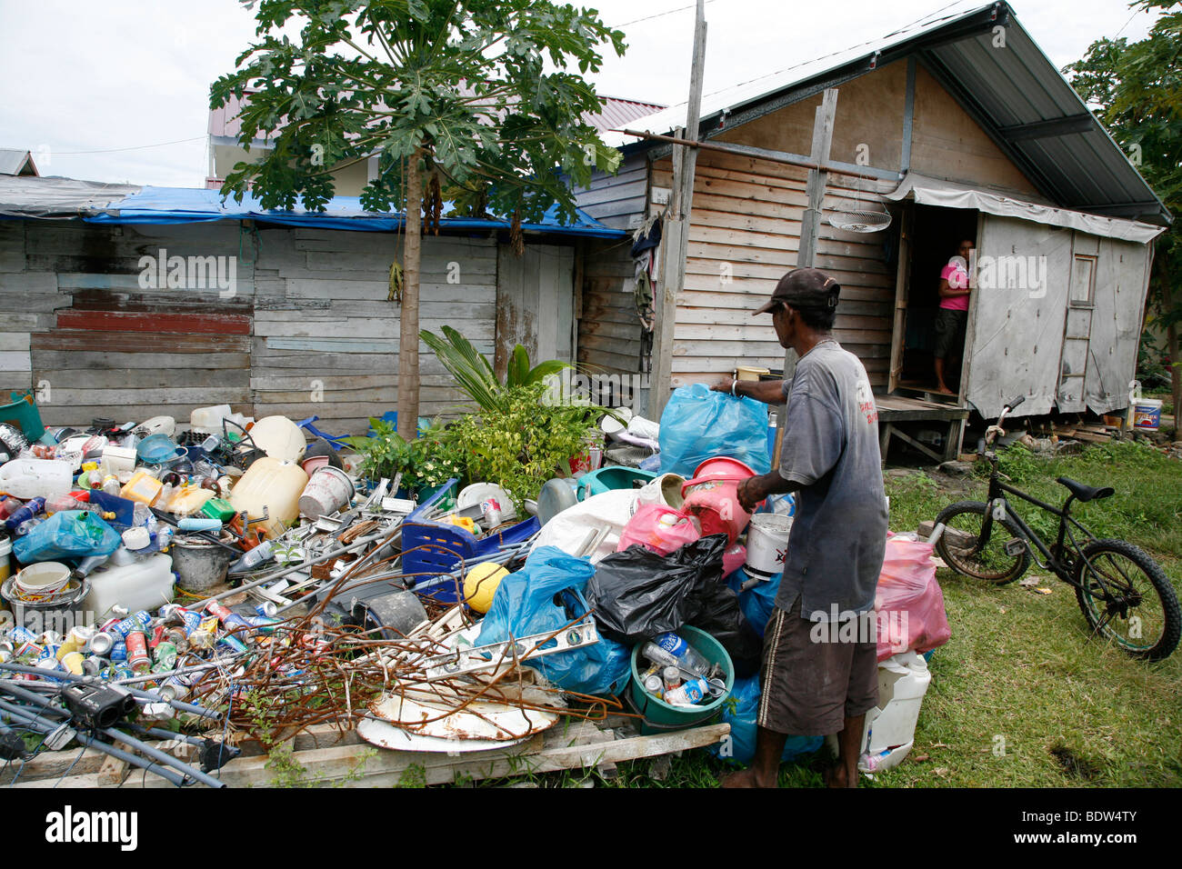 INDONESIA Sofyan Mohammed Yusuf, un reciclador de basura y CRS nueva casa beneficiario, clasificación recycables. Foto de stock